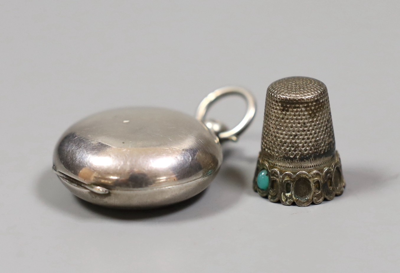 An Edwardian silver sovereign case, Birmingham, 1907 and an 800 standard white metal thimble.
